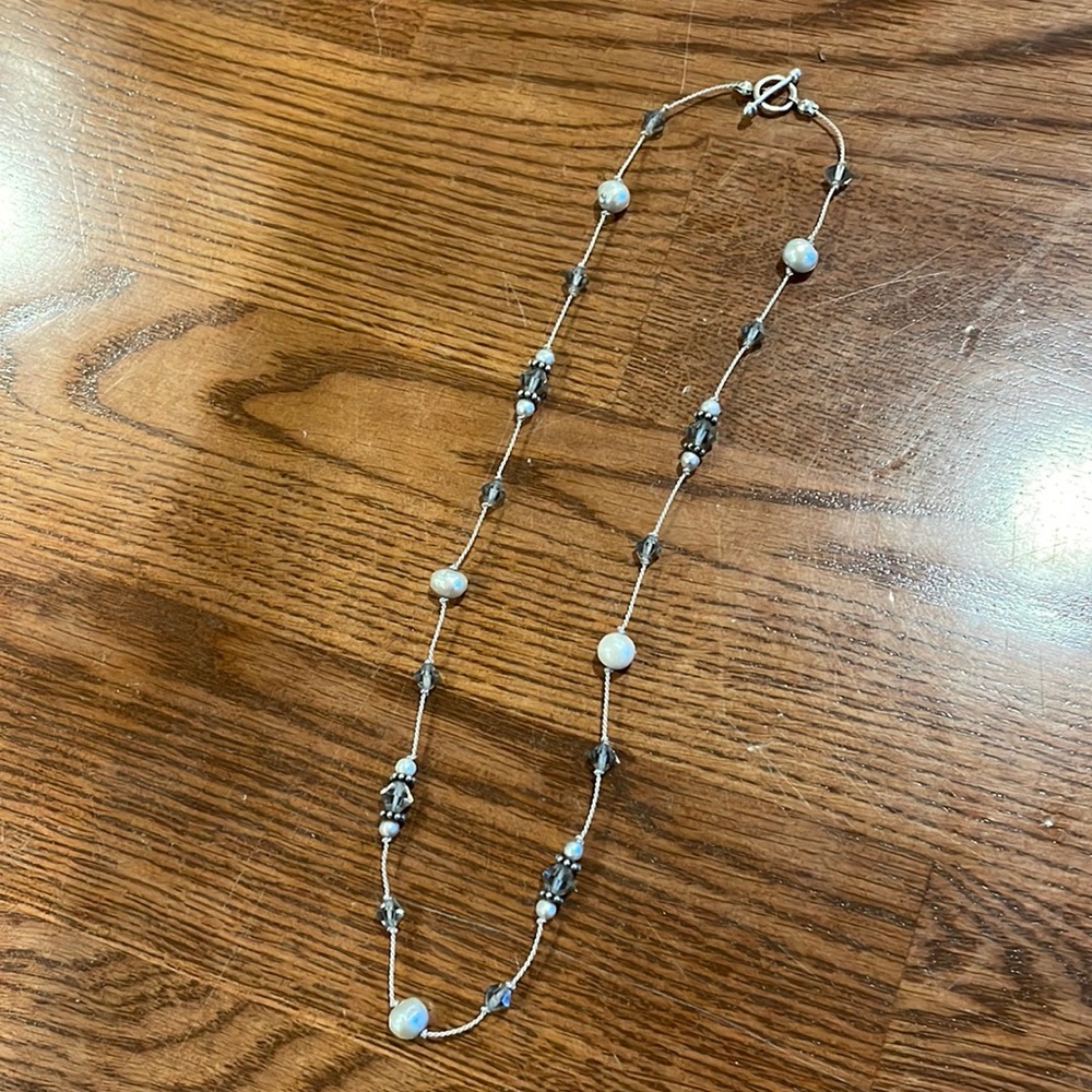 Delicate beaded necklace with white pearls and grey gem accents